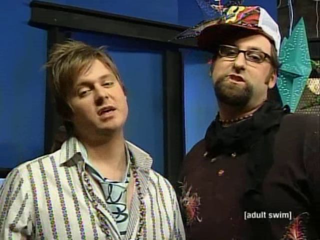 Screenshot from Tim and Eric Awesome Show Great Job where the hosts are parodying 00s MTV style TV and are dressed/styled like super cool edgy skaters of that era.