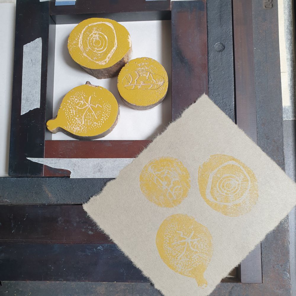 Woodblocks on press having just been printed with the print beside.