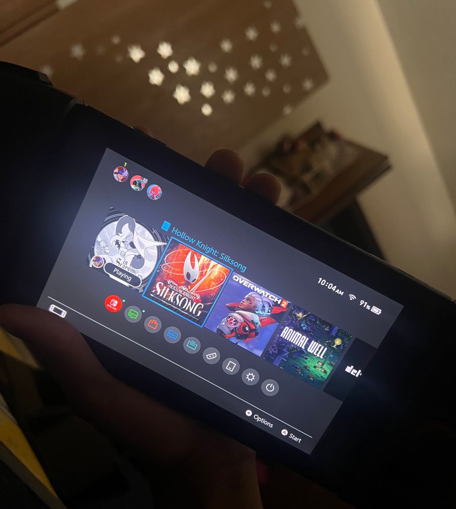 hollow knight's sequel SILKSONG downloading onto a nintendo switch. the 6 year wait is finally over