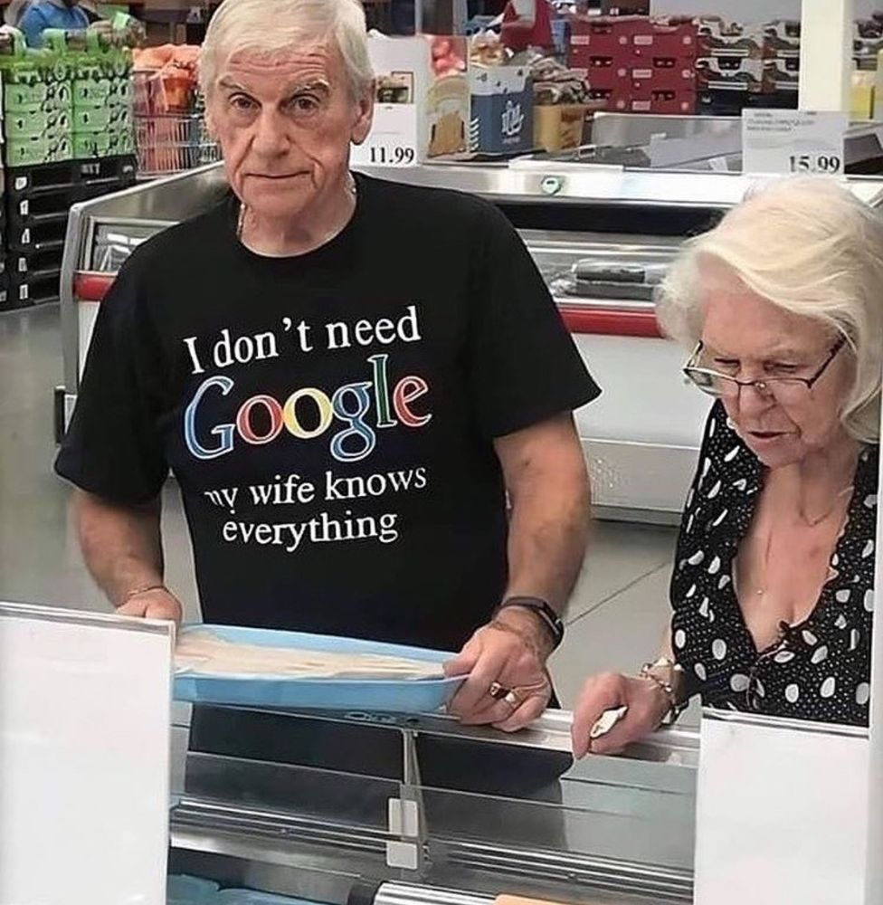 Un homme fait les courses à Costco avec sa femme. Il porte un t-shirt sur lequel est écrit  "I don't need Google, my wife knows everything".