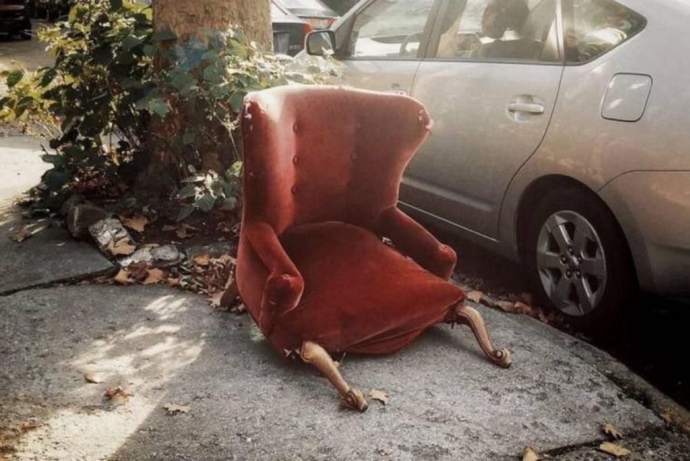 Un fauteuil en velours rouge (d'époque Régence ?) abandonné sur le trottoir. Il a les pieds cassés ce qui lui donne l'air d'être avachi par terre comme le serait quelqu'un très fatigué ou un alcoolique