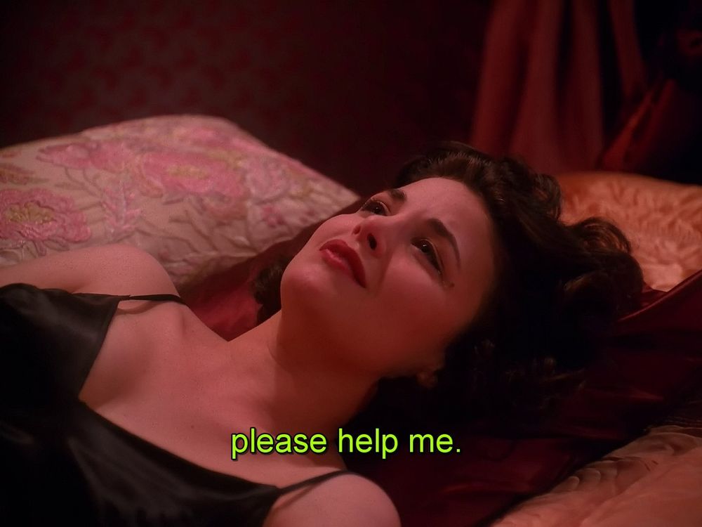 Sherilyn Fenn as Audrey Horne in an episode of Twin Peaks. She appears sad and frightened while lying on a bed. The caption says, "please help me."