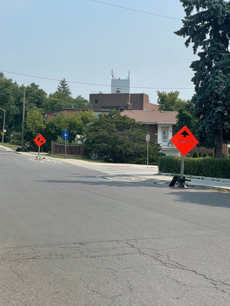 An empty street with two construction signs blocking the marked bike lane