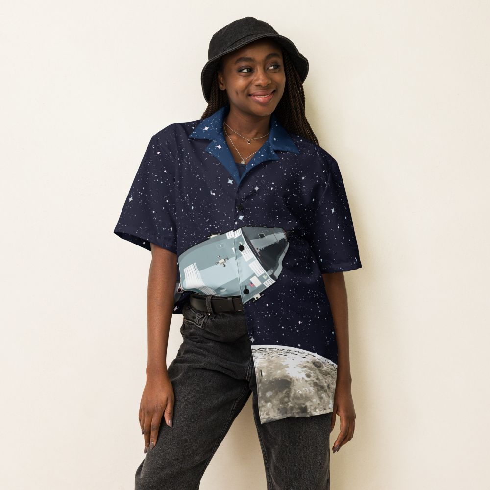 A woman wearing a baggy shirt featuring the Apollo Command and service module in orbit around the moon