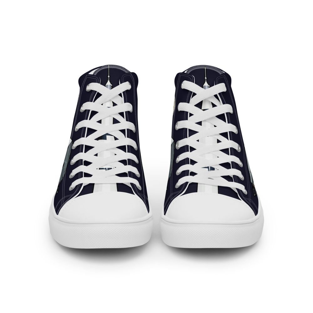 The front-on view of a pair of high-top trainers made of dark blue canvass. The angle shows the Saturn V rocket on the tongues, behind the shoelaces