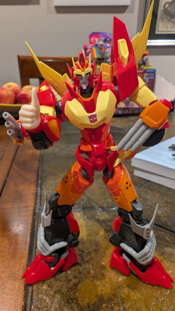 Picture of Furai model kit More Than Meets The Eye Rodimus Prime. One of his hands has been replaced with a human doll hand giving a thumbs up.