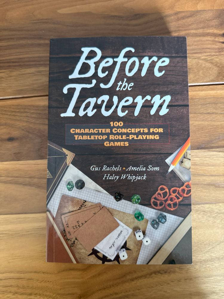 A copy of “Before the Tavern: 100 Character Concepts for Tabletop Role-Playing Games” by Haley Whipjack, Gus Rachels, and Amelia Som.