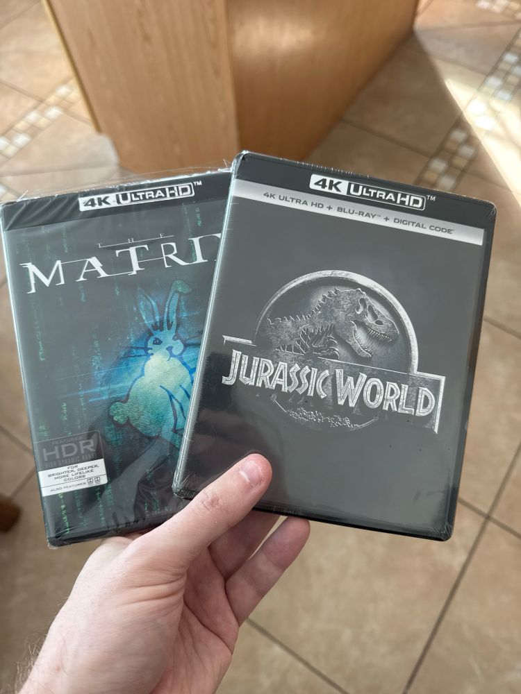 The movies The Matrix and Jurassic World on 4K UltraHD Blu-ray.