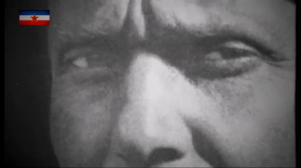 a close up of a man 's face with a red white and blue flag in the background