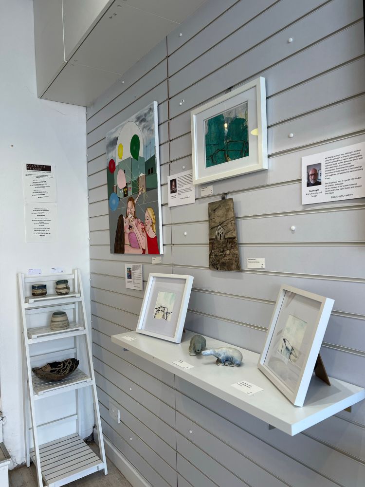 A shot of the gallery wall with ceramic polar bears, paintings and pots.