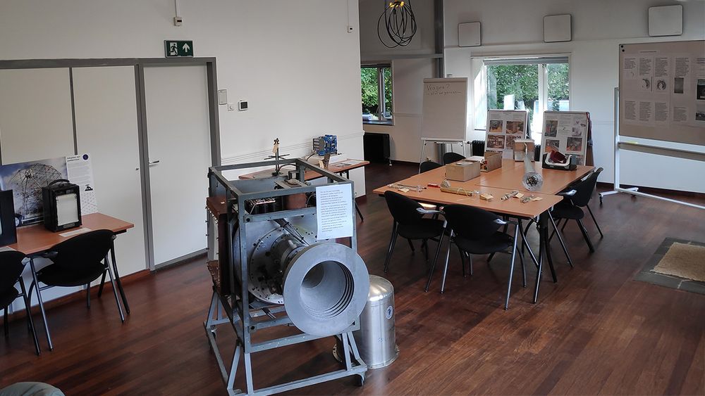 Een zaal met tafels met elektronica. Op de voorgrond een metalen constructie met een hoornantenne, die vroeger in de Dwingeloo telescoop zat.