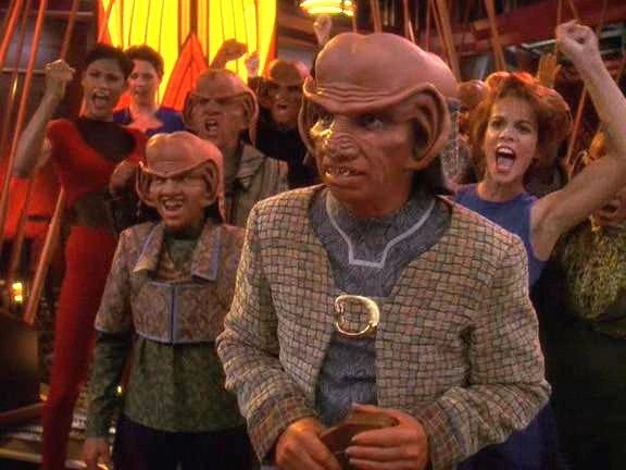 Rom as a union organizer in Quark's Bar, with his coworkers raising their fists behind him.