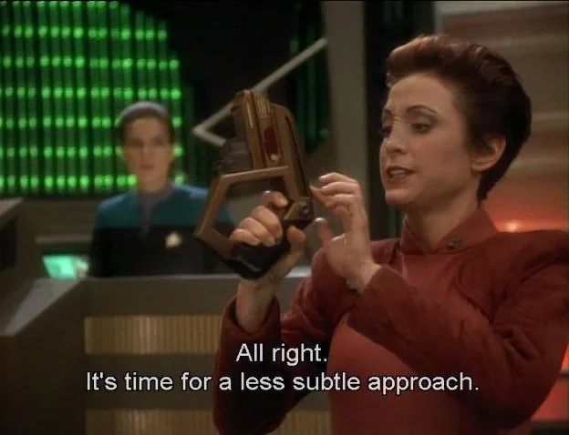 Major Kira adjusts the controls on a Bajoran phaser, saying, "Alright. It's time for a less subtle approach."
