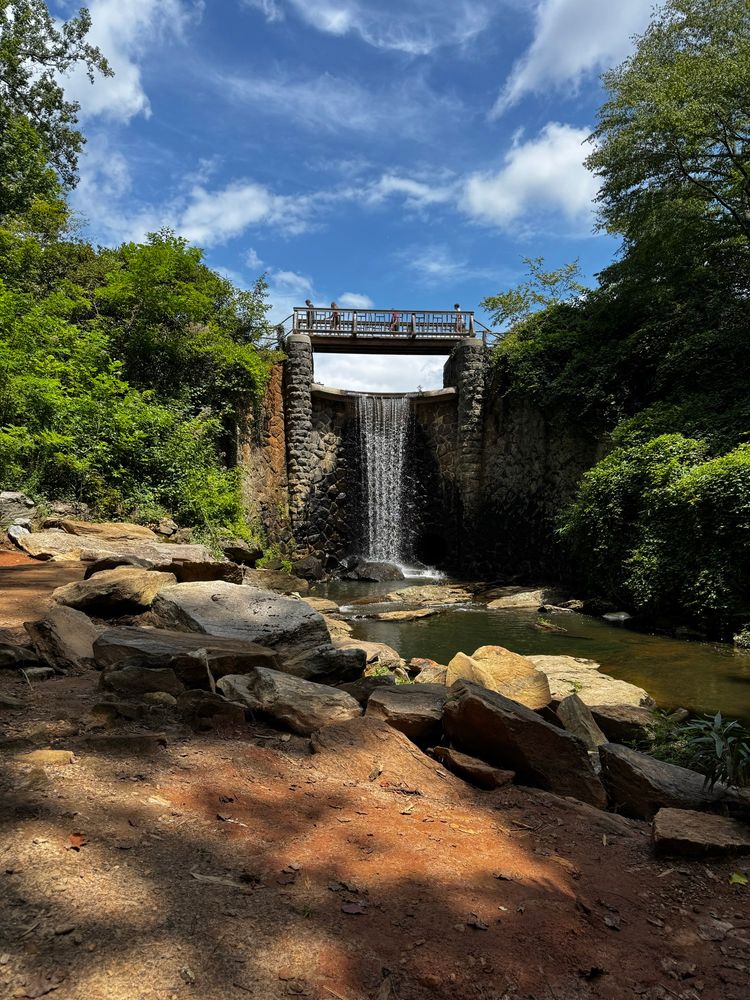 A bridge / mini waterfall splashing into large rocks, shit be idealic