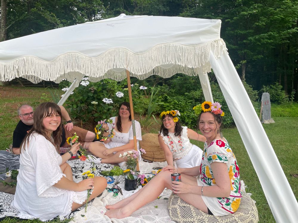 Midsommar party under awning whites dresses, pretty people,  flower crowns, smiling faces