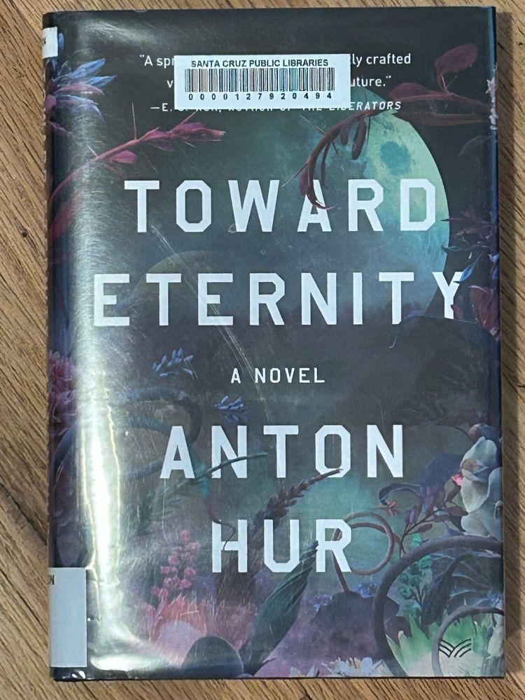 Library book with black floral cover art and white text: Toward Eternity a novel Anton Hur