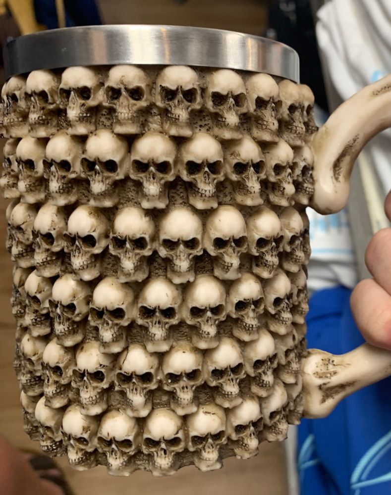 A mug with a shit ton of skulls covering it. The handle is a bone.