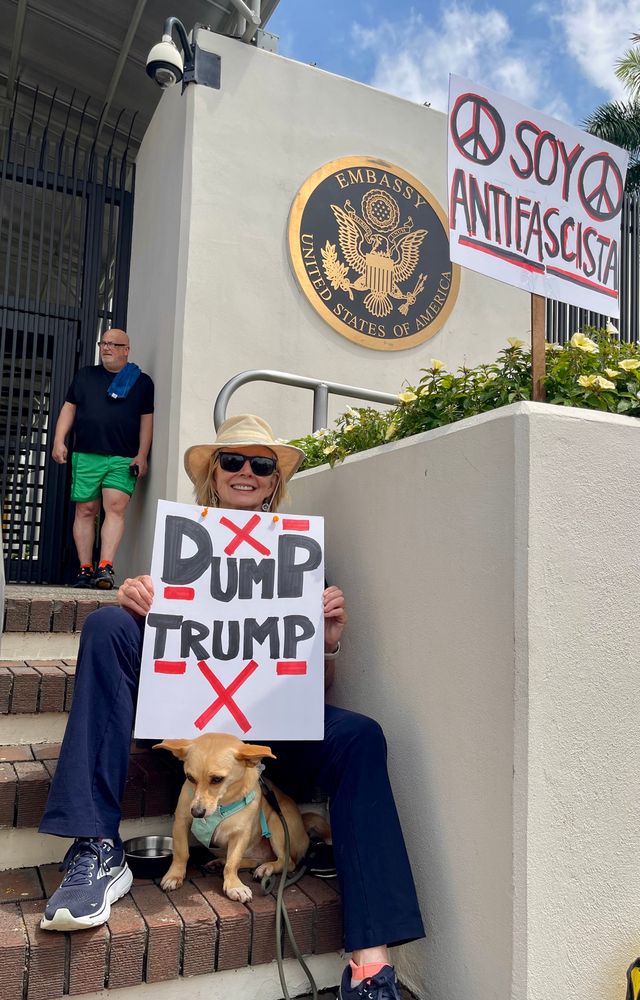 No Kings Day Protestor at the U.S. Embassy in San Jose Costa Rica with a dog and sign that says Dump Trump
