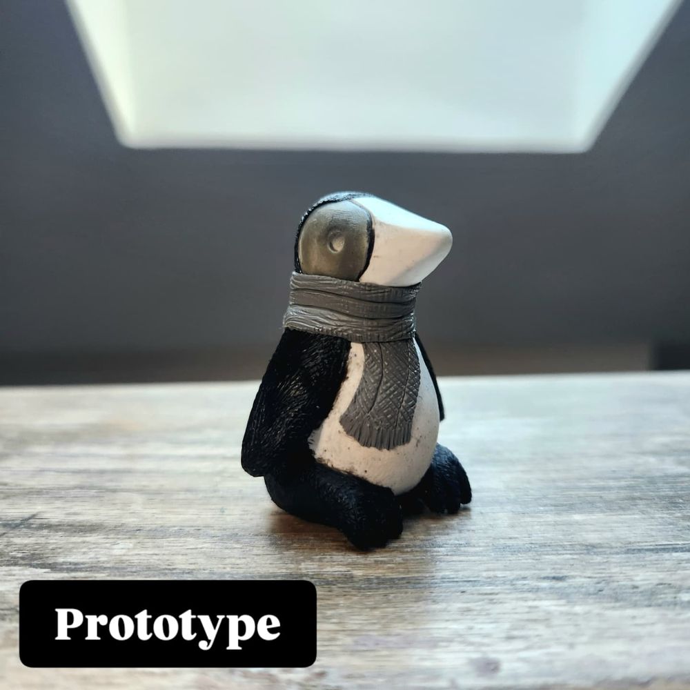 Penguin sculpture wearing a colorful scarf.