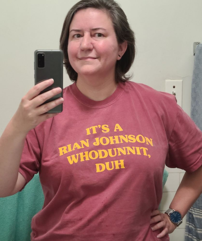 Me, a middle-aged woman with brown hair, wearing a shirt that reads "it's a Rian Johnson whodunnit, duh"