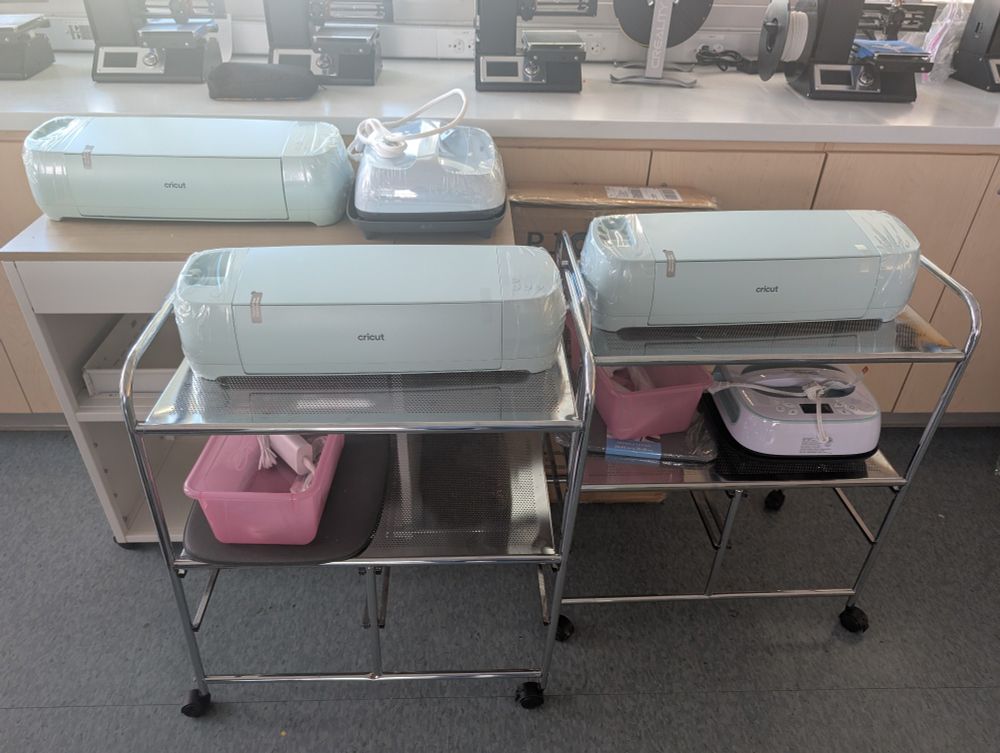 Three cricut vinyl cutters on carts