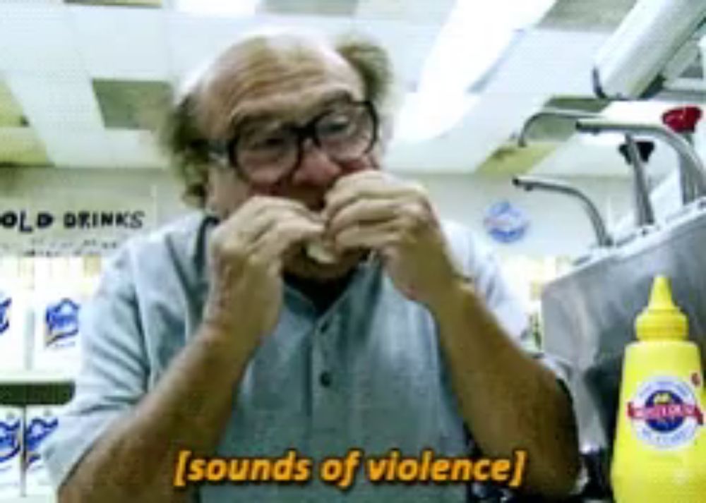 a man eating a sandwich with the words sounds of violence behind him