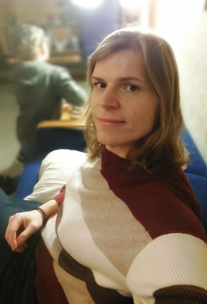 Ich im Museum, mit Pullover und offenen Haaren auf einem Sofa