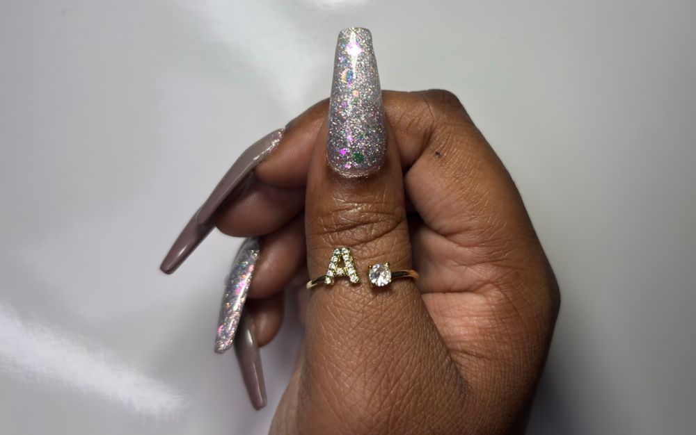 Thumb nail with iridescent glitter beside gray to mauve thermal changing nails. 