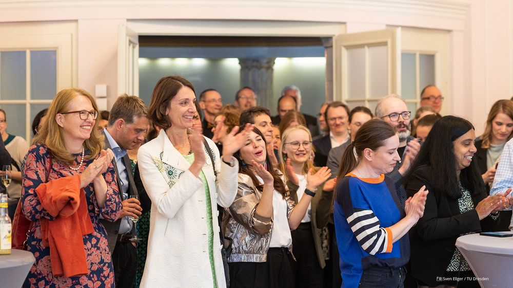 Picture of cheering guests in the ballroom of the Rectorate Building.