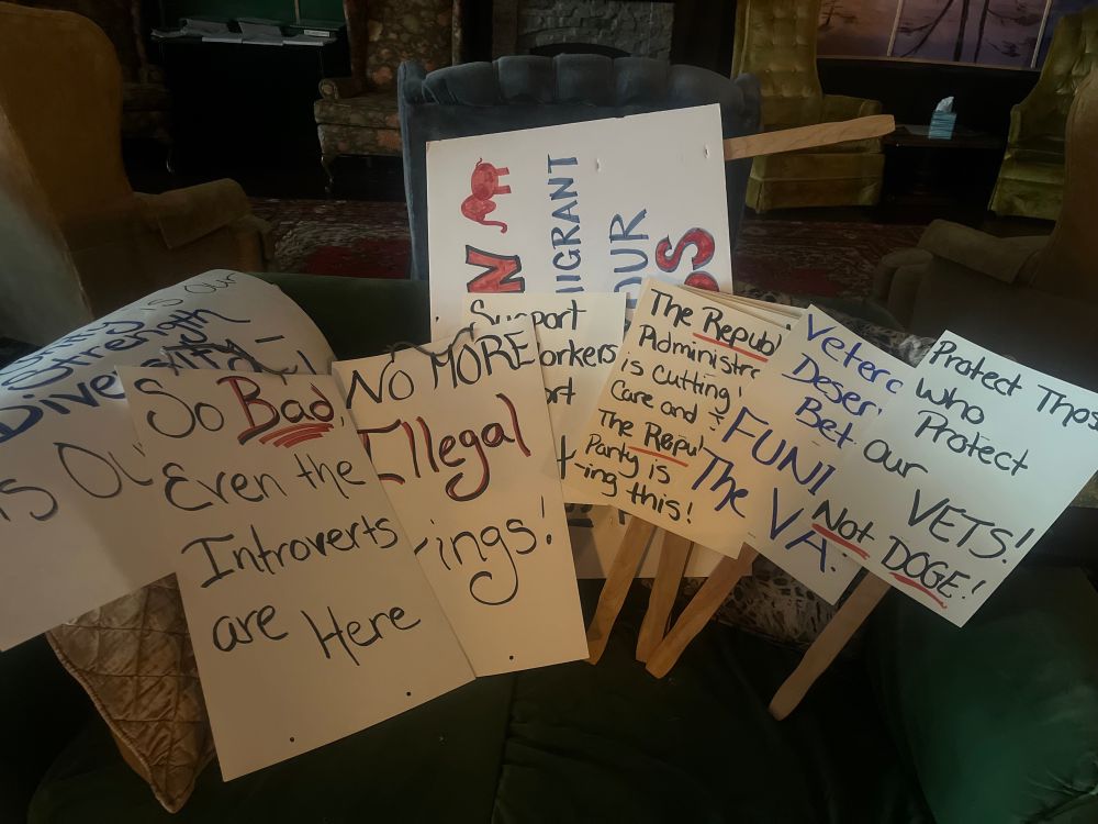 A collection of signs made for the rally sitting in a green couch. 