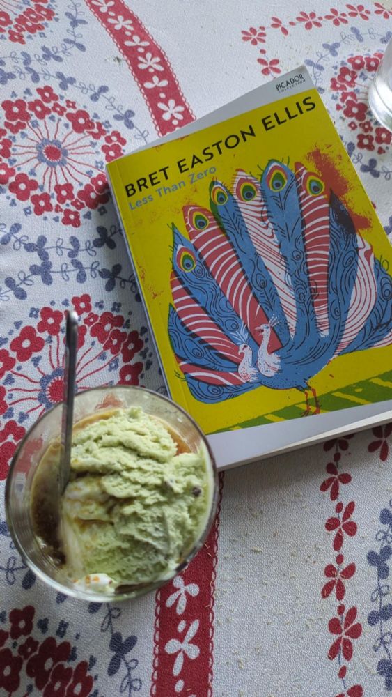 Pistachio Vanilla ice coffee with Bret Easton Elllis's Less than Zero on a colorful tablecloth 
