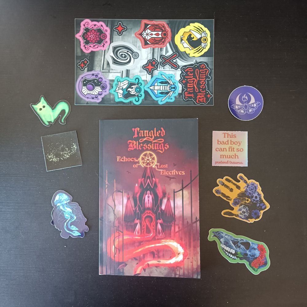 A photograph of a book laid out on a table, surrounded by colourful stickers. The book is "Tangled Blessings - Echoes of Lost Electives", a magic academy horror RPG for 1-2 players
