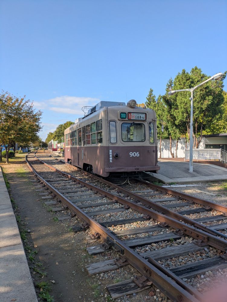 An old green amd beige tram going to "Hiroshima Docks" 