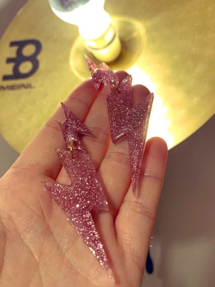 Große, rosa glitzernde Ohrringe in Blitzform