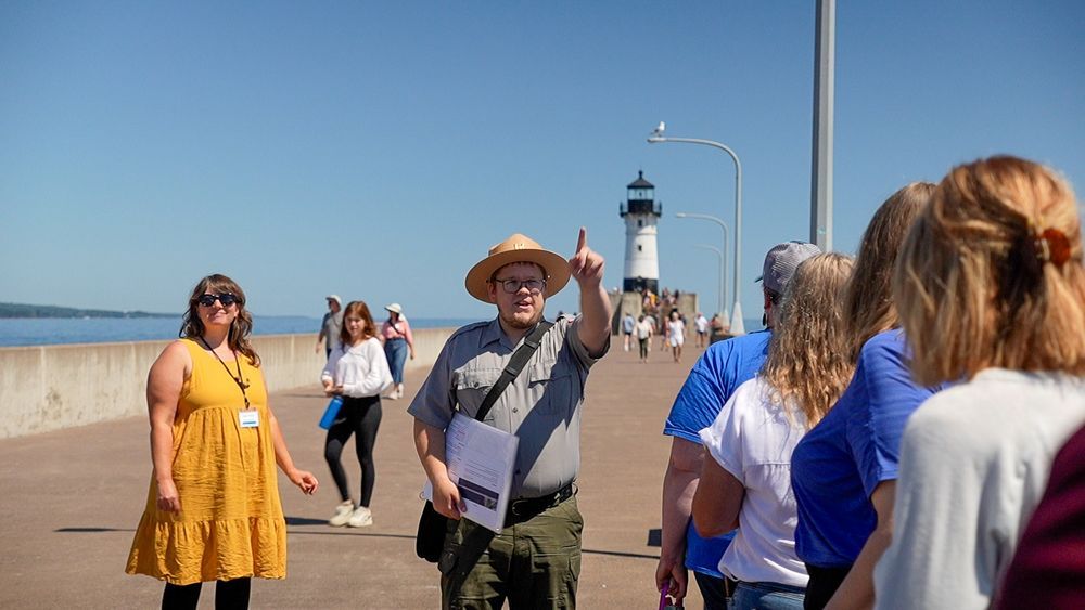 A ranger points into the distance as he gives educators a tour at the Duluth Entry lighthouse. Credit: Cait Dettmann/MNSG.