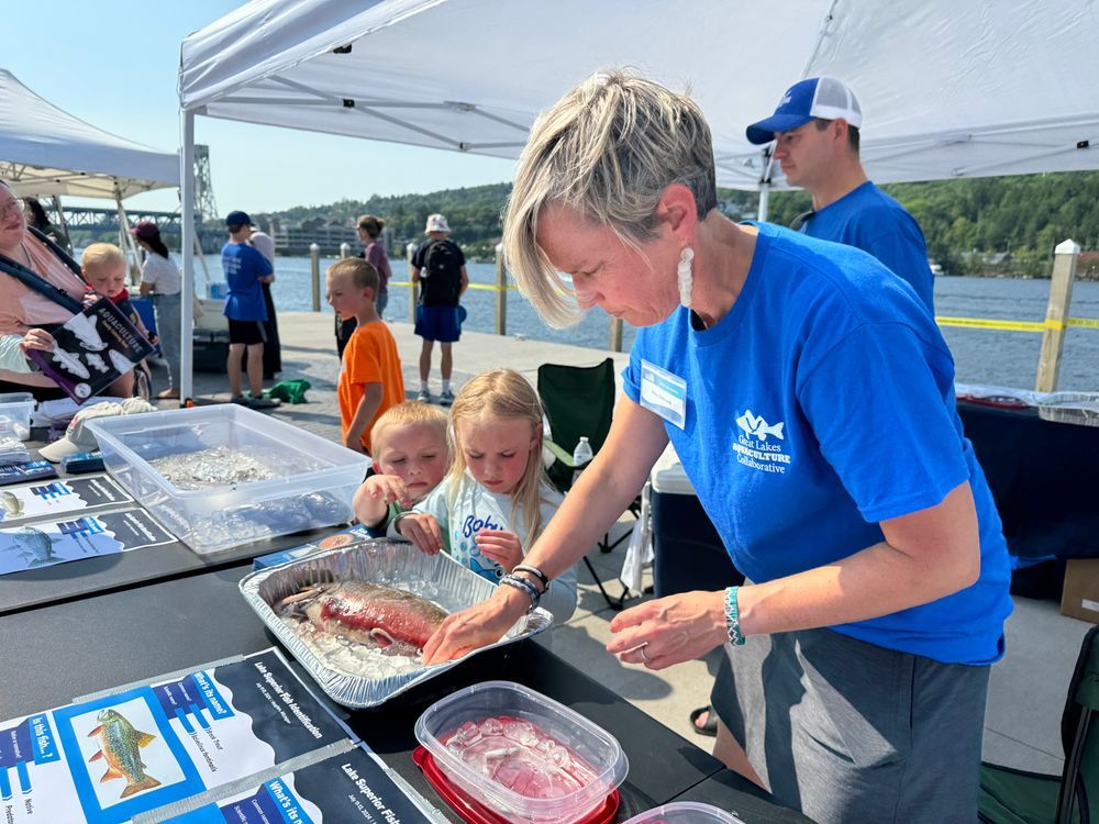 Amy Schrank, right, teaches small children about Great Lakes fish using a sample. Credit: M. Thoms/MNSG.