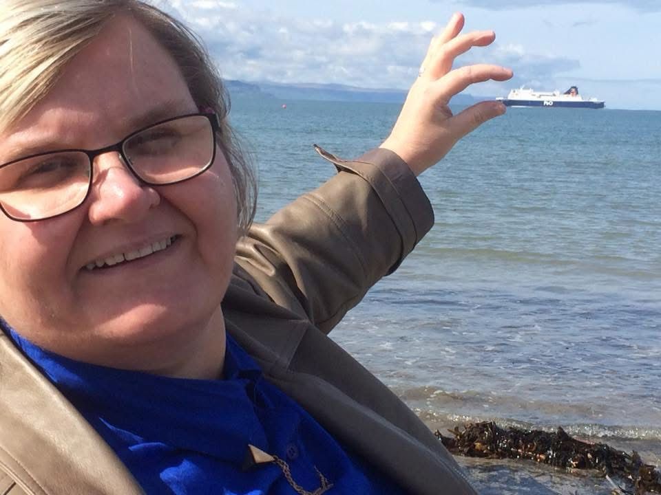 A woman holding a ferry in the distance in her hand