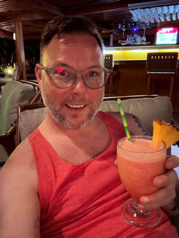 KP wearing a pink tank top, enjoying a tropical mocktail before dinner 