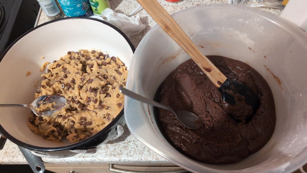 Picture of 2 bowls, one containing homemade cookie dough and the other containing homemade brownie batter 