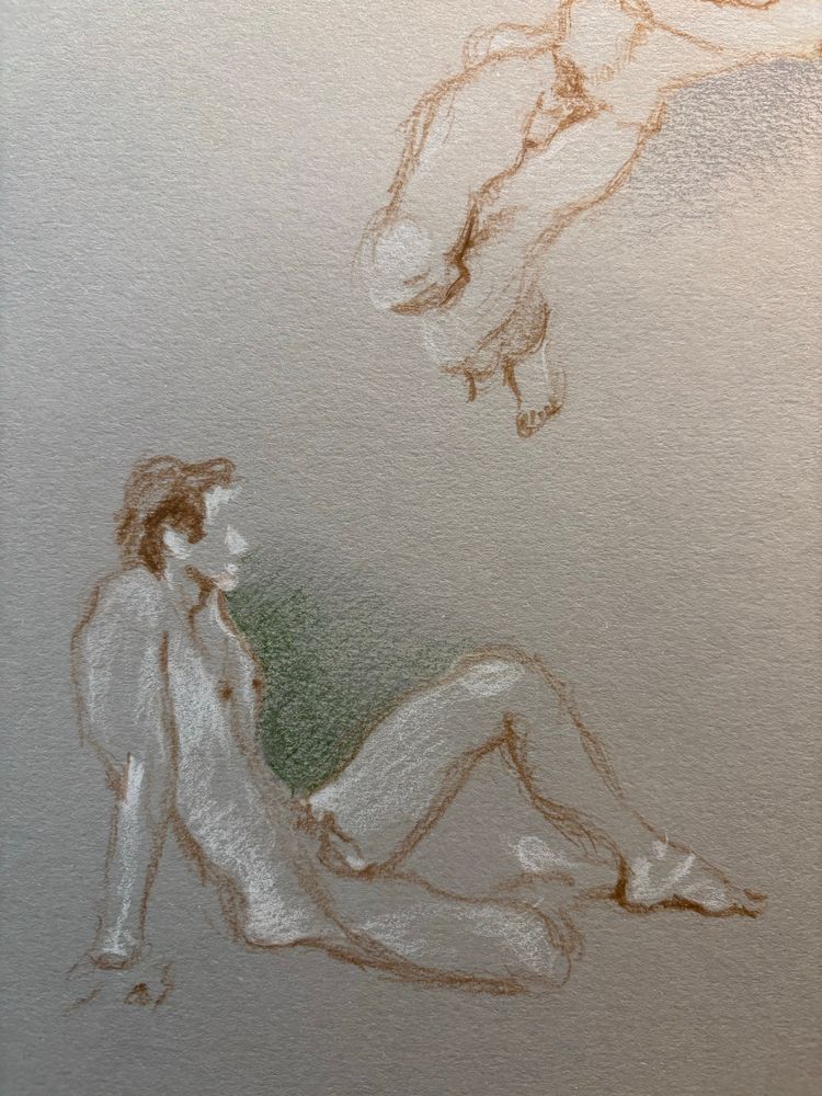 Male nude model sitting on floor with arms behind him