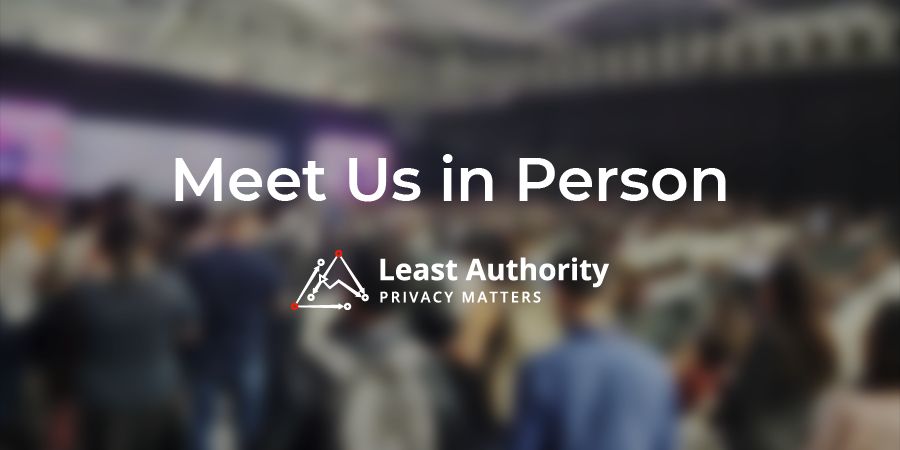 A blurred image of a crowd gathered at a conference event stage with the tagline "Meet Us in Person". 