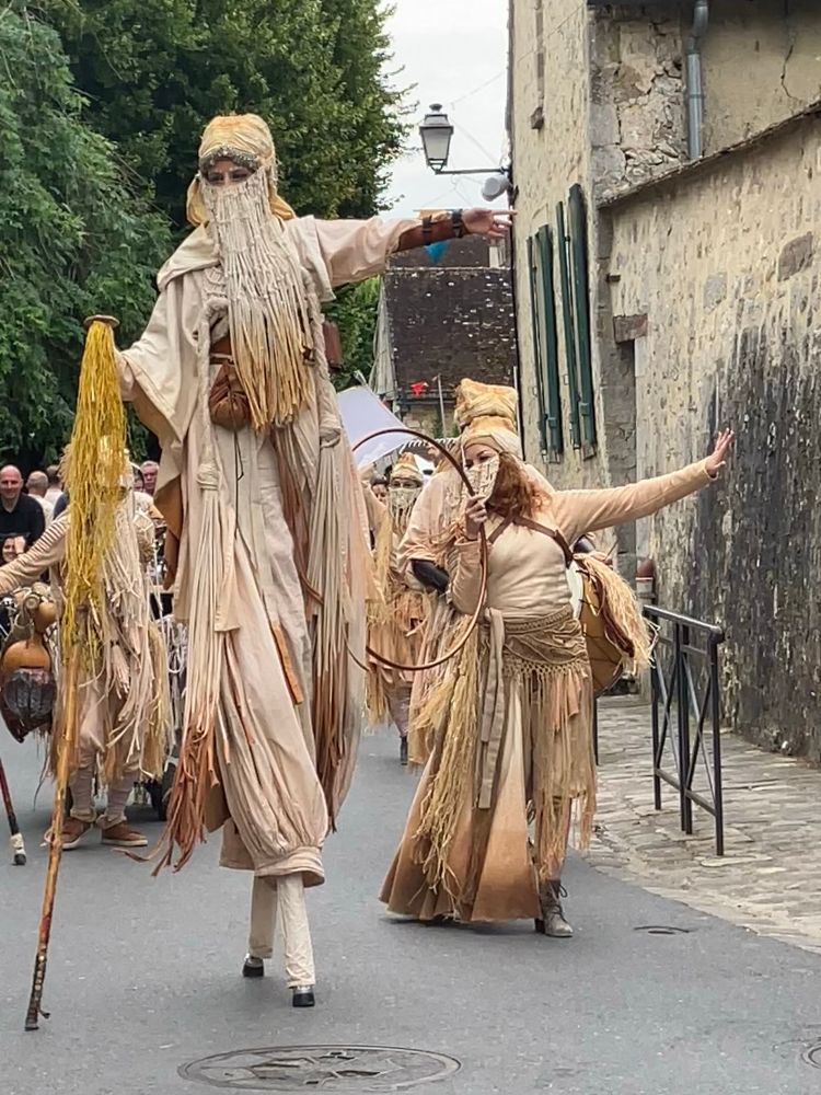 a group of street artists dancing on stilts 