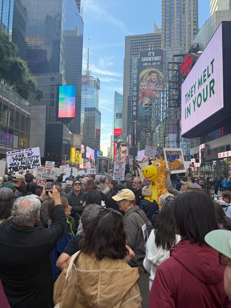 group of protesters with signs in the middle of times square, nyc