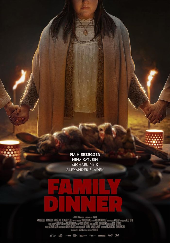 Poster for Family Dinner (2022). Poster shows a family holding hands standing around a plate on which is a carved rabbit.