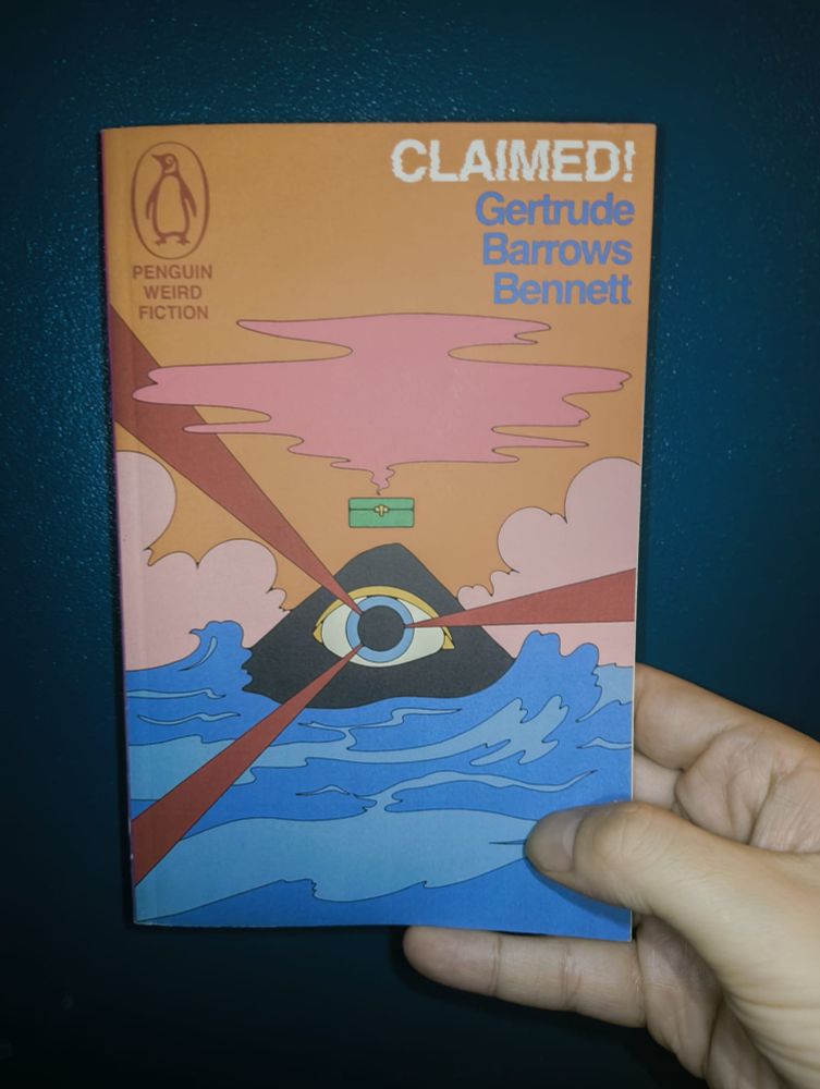 The book Claimed! by Gertrude Barrows Bennet as published by Penguin Weird Fiction. The cover shows an illustration of a mountainous island with an eye with bright blue sea below and orange sky above. Above the island is a green box with a mysterious pink cloud escaping from it.