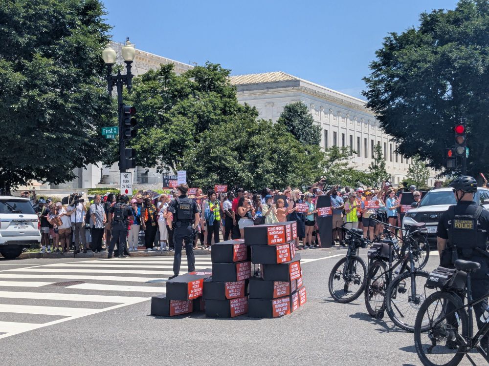 Protestors and cardboard coffins near the Capitol in DC with police on bikes