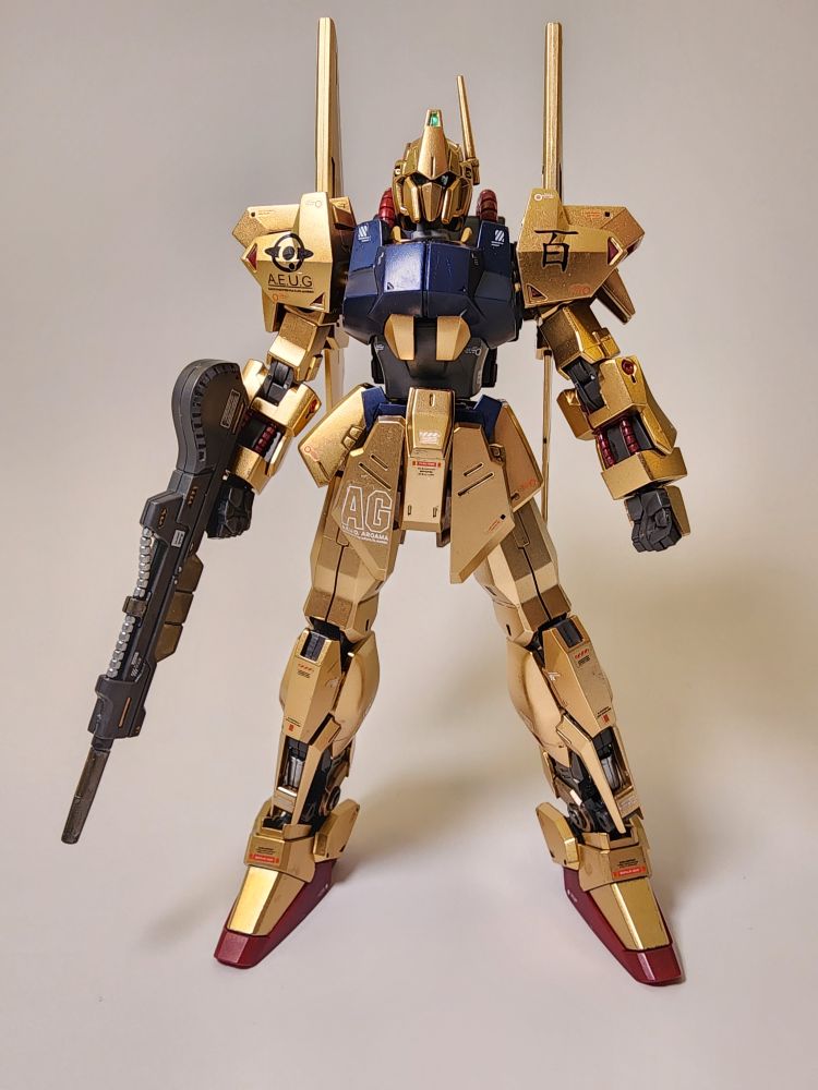 A completed JMS bootleg kit of the HG Hyaku Shiki from Zeta Gundam. The Kit is standing facing the camera and is holding its rifle in its right hand.