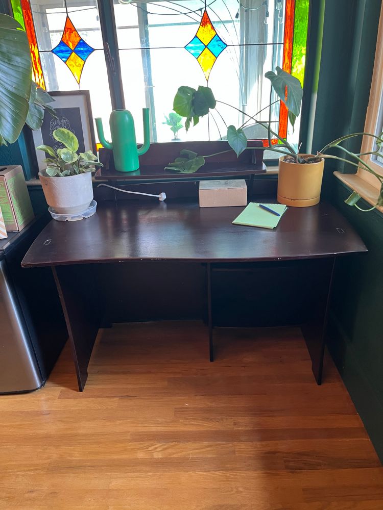 A puzzle desk in front of a stained glass window.