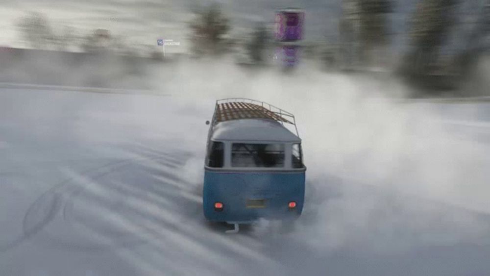 a blue and white van is driving through the snow and smoke is coming out of it