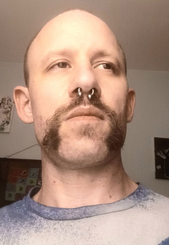 A closeup of theBigBadMe sporting a fresh handlebar mustache, while looking wistful to the distance.